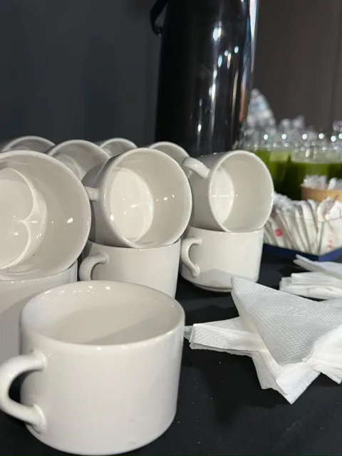 Xícaras brancas e copos organizados para serviço de café